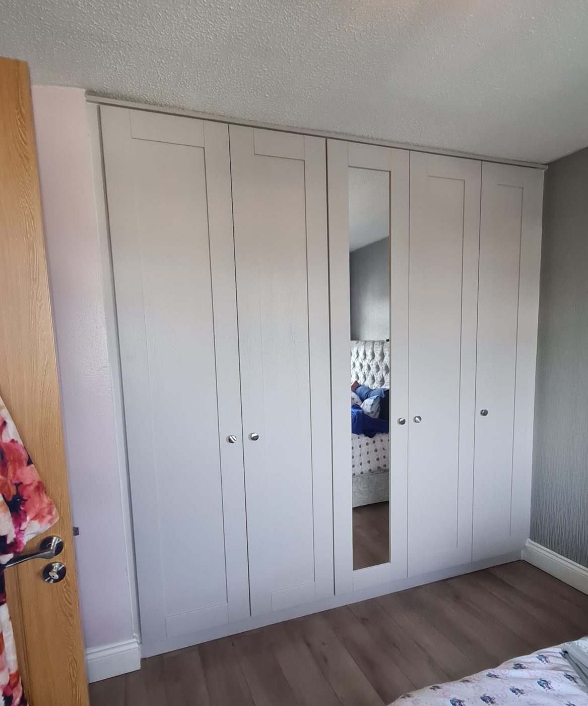 Grey shaker wardrobes with a mirrored centre door
